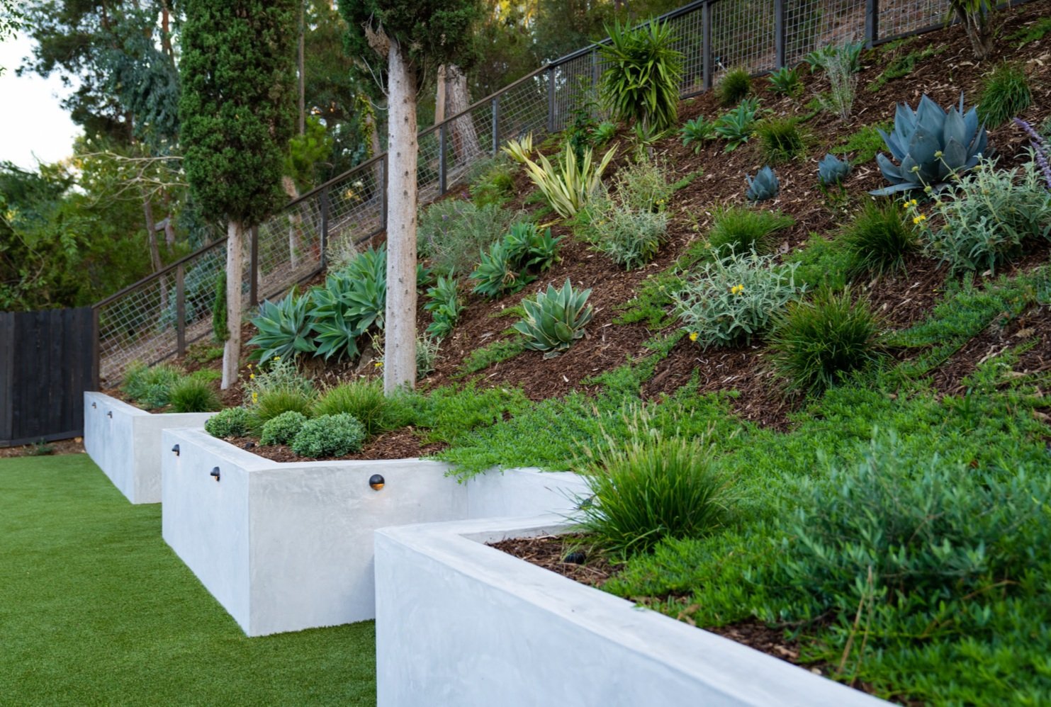 一个由人造草坪和聪明的景观设计决定改造的倾斜庭院beplay手机官网app