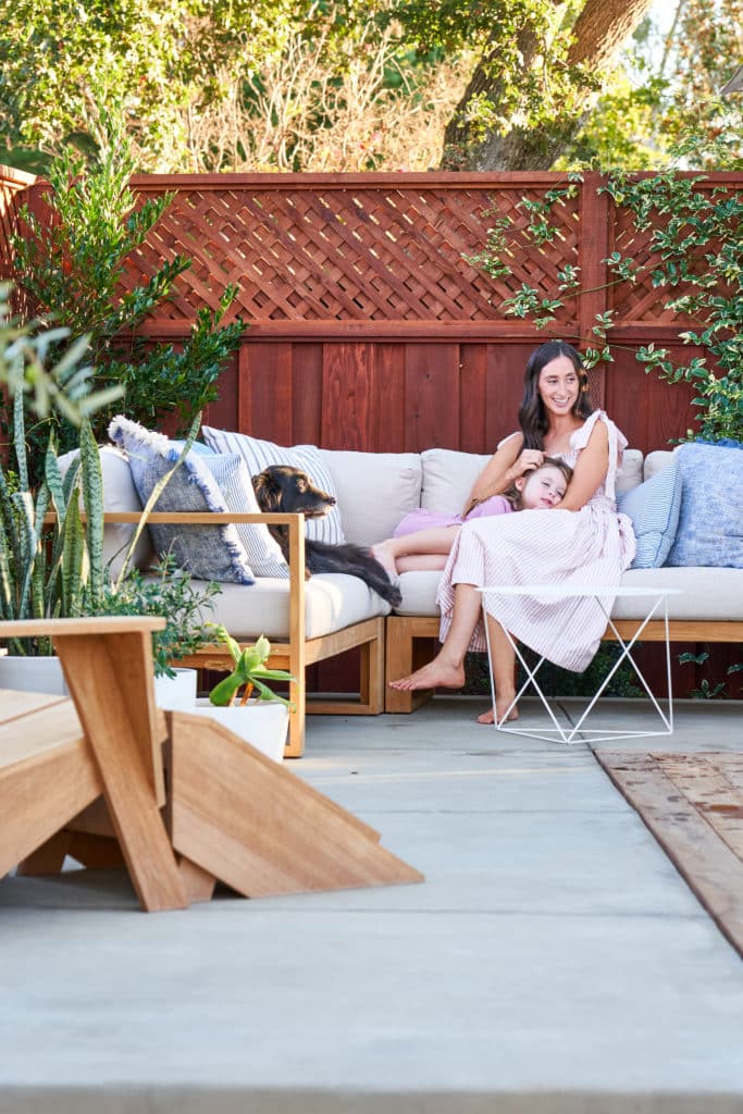 克里斯蒂，她的女儿和家里的狗在他们新的混凝土露台上享受他们的户外组合。