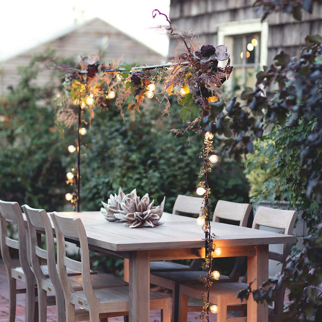 后院的场景与桌子和椅子与超过桌杆与绿色植物装饰